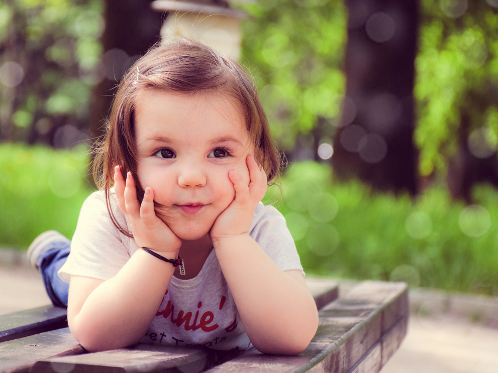 Little Girl Lying on Wooden Table