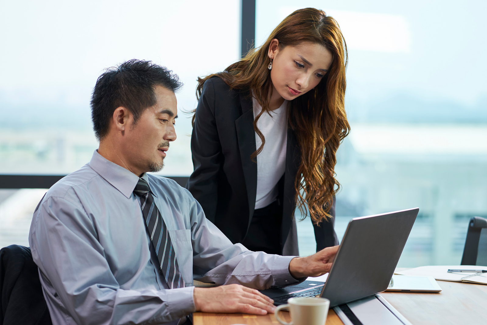 asian business manager talking to assistant in office