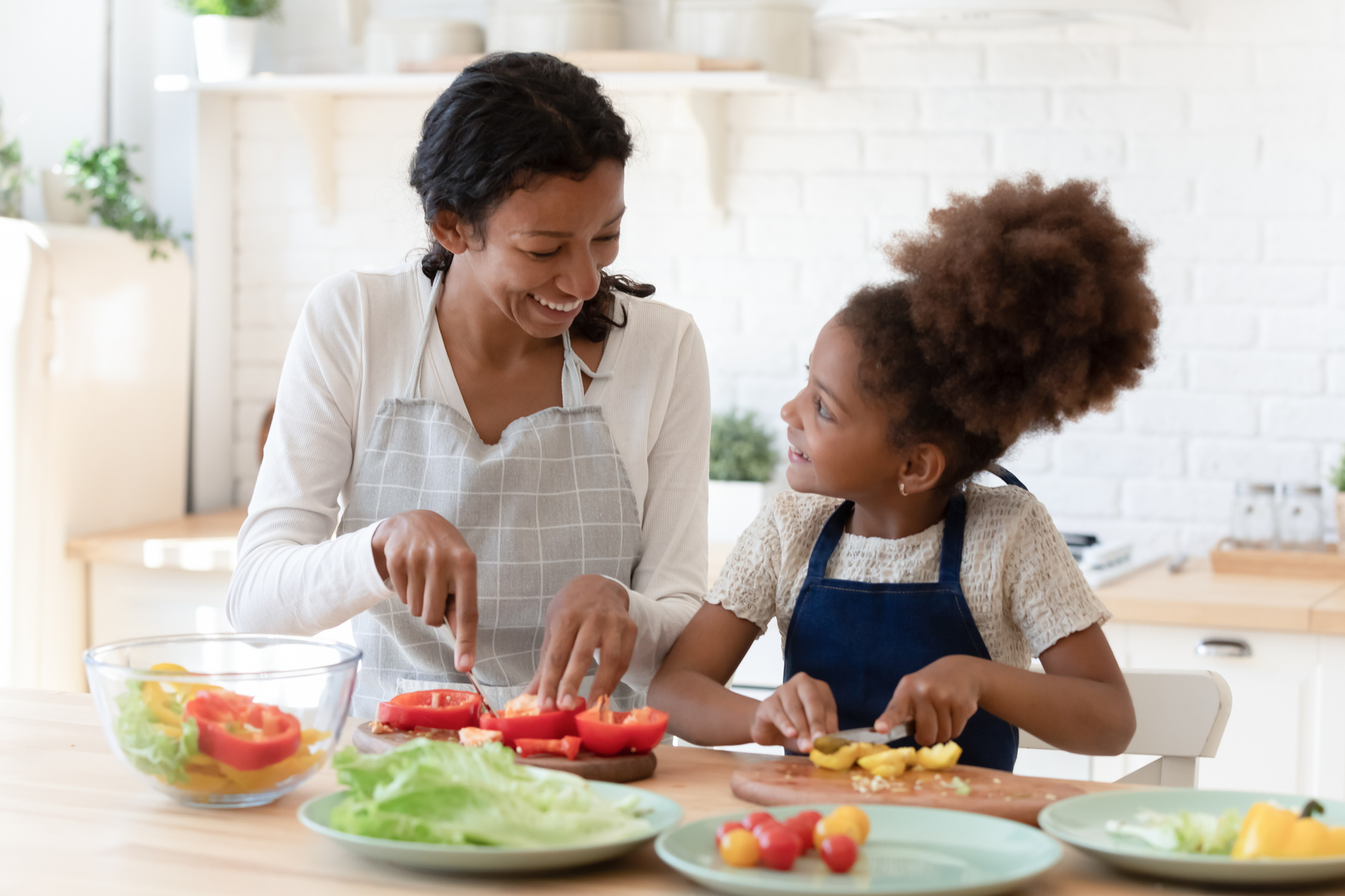 Happy patient black mom teaching little daughter prepare healthy nutrition