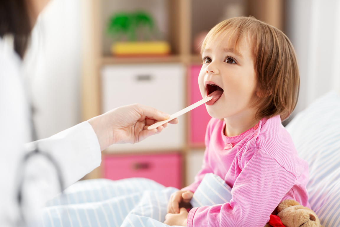 Doctor Checking Sick Girl's Throat at Home