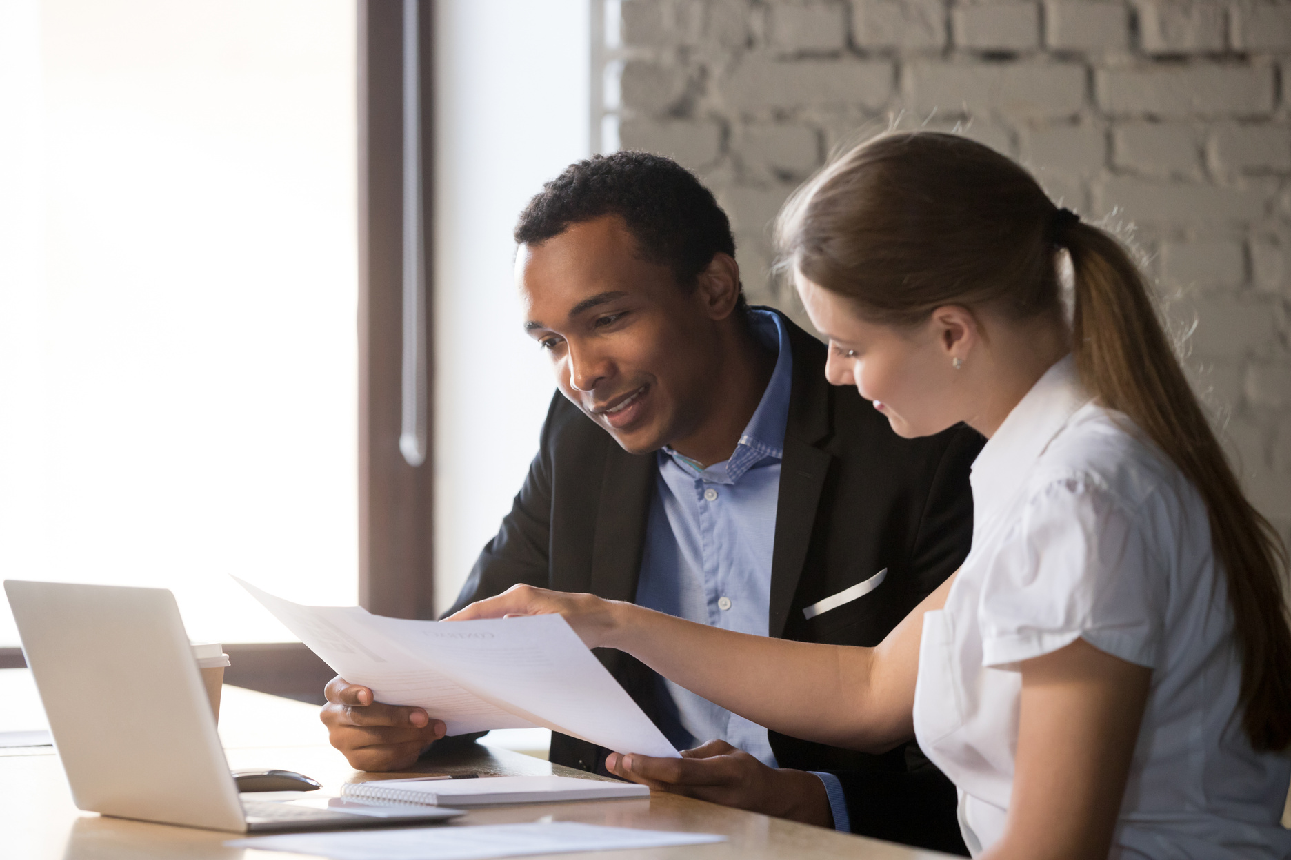 Female financial advisor insurer consulting male african-american client about contract