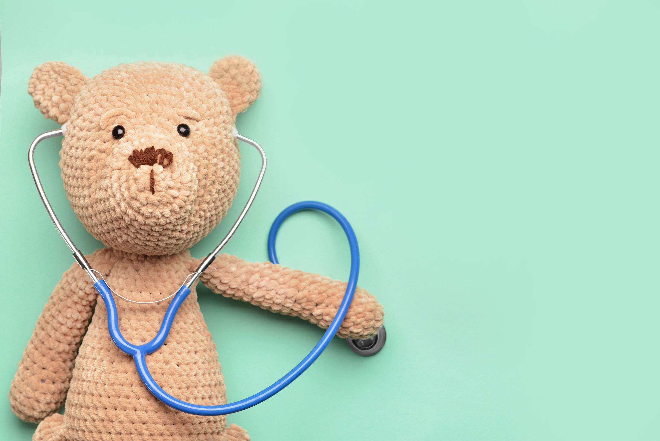 Stethoscope and Baby Toy on Green Background