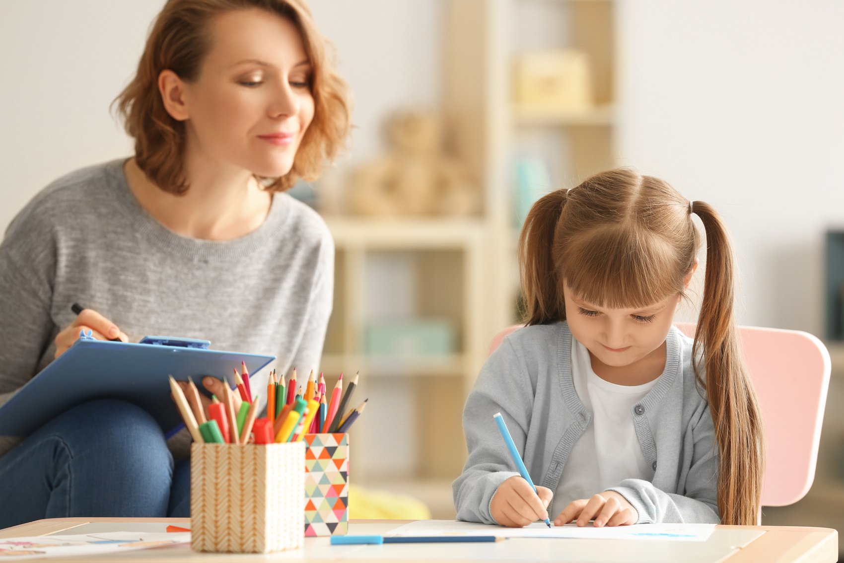 Female Psychologist with Cute Little Girl During Art Therapy