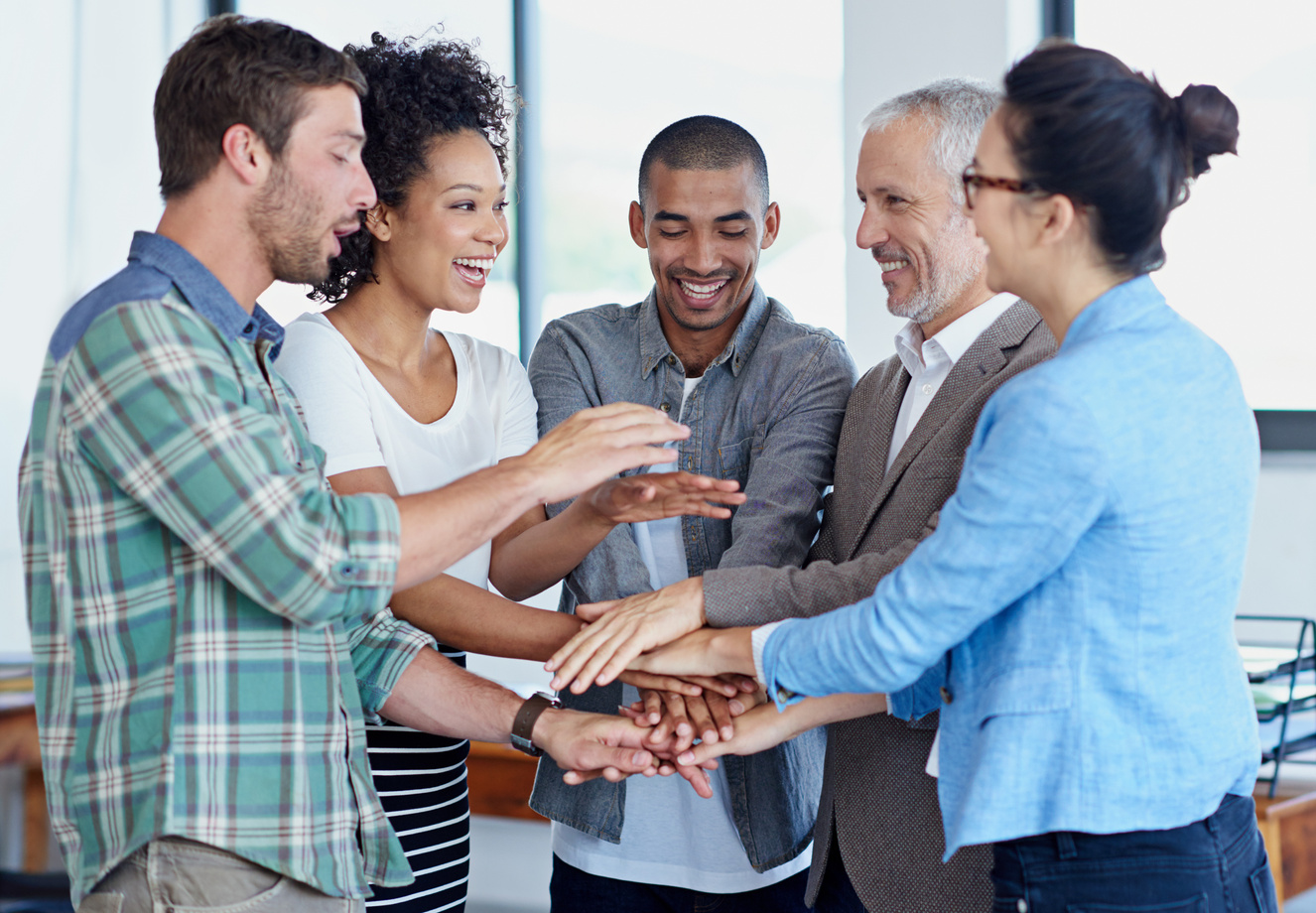 Pulling together. Shot of a group of happy coworkers standin